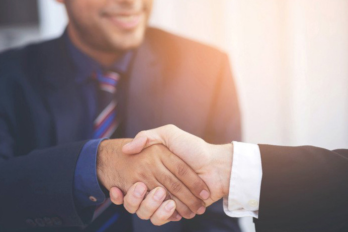 Two people in suits shaking hands